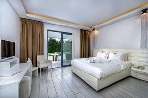Schlafzimmer im Diamond Deluxe Hotel mit Doppelbett, Fernseher, und Balkon