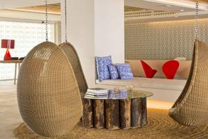 Loungebereich des ME Ibiza Hotels mit zwei Hängesesseln und einem Tisch.