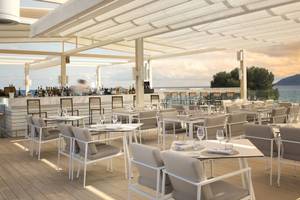 Außenterrasse des ME Ibiza Hotels mit Blick auf das Meer.