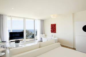 Innenansicht einer Suite im ME Ibiza Hotel mit Meerblick, modernem Interieur und Panoramafenstern.