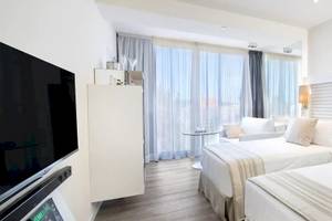 Doppelzimmer im ME Ibiza Hotel mit moderner Einrichtung und Aussicht auf die Stadt.