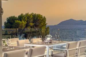 Terrasse des ME Ibiza Hotels mit Blick auf das Meer und die Berge