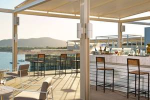 Dachterrasse des ME Ibiza Hotels mit Blick auf das Meer und die Berge.