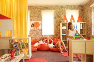 Zwei Kinder spielen in einem farbenfrohen Zimmer des Pelekas Monastery Hotels.
