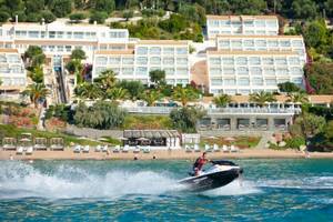 Ein Mann fährt auf einem Jet Ski am Strand vor dem Pelekas Kloster Hotel.