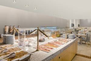Frühstücksbuffet im Pelekas Monastery Hotel mit vielen Speisen und Geschirr.