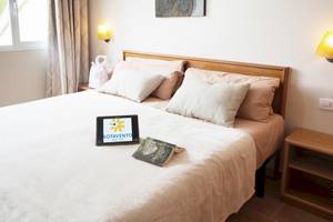 Schlafzimmer im Sotavento Beach Club mit Tablet und Buch auf dem Bett.