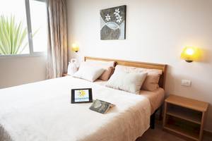 Schlafzimmer im Sotavento Beach Club mit Bett, Büchern und Nachttischen.