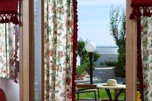 Aussicht aus dem Zimmer des Mitsis Rinela Beach Hotels mit Tisch, Hut und Garten