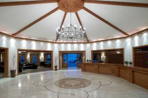 Lobby des Mitsis Rinela Beach Hotels mit Kronleuchter und Marmorboden.