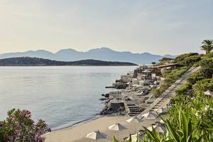 Außenbereich des Minos Palace Hotel & Suites mit Blick auf das Meer und die Berge.