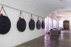 Eingangsbereich des Minos Palace Hotel & Suites mit fünf schwarzen Gongs an der Wand.