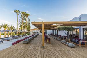 Lounge-Bereich des Minos Palace Hotel & Suites mit Holzdeck, Sitzgelegenheiten und Überdachungen