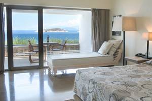 Minos Palace Hotel Suite mit Meerblick, Bett, Lounge-Bereich, Tisch und Telefon