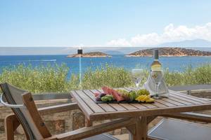 Balkon des Minos Palace Hotel & Suites mit Blick auf das Meer und eine Obstplatte.