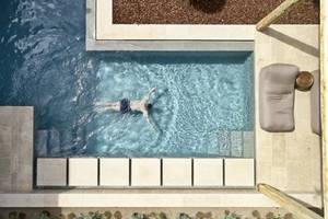 Ein Schwimmer im  Infinity-Pool des Minos Palace Hotel & Suites.