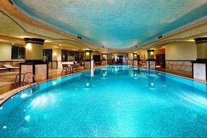 Ein großer Innenpool im Side Sun Hotel mit blauen Fliesen und einer blauen Decke.