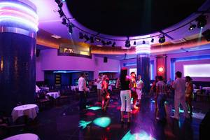 Disco-Saal im Side Sun Hotel mit bunten Lichtern und tanzenden Gästen.
