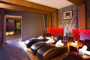 Massage-Lounge im Side Sun Hotel mit roten Wänden und Lederliegen.
