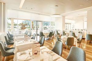 Innenansicht des Restaurants im Hipotels Playa de Palma Palace mit gedeckten Tischen und Stühlen.