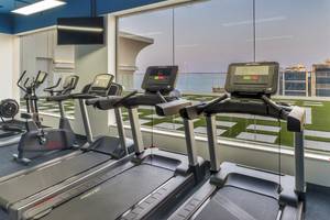 Fitnessraum im Royal Central Hotel The Palm mit Blick auf die Skyline.