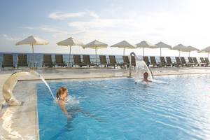 Mensch schwimmt im Pool des Domes of Corfu, Autograph Collection mit Blick auf die Sonnenliegen