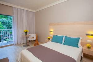 Hotelzimmer im Domes of Corfu, Autograph Collection mit Balkon, Tisch, Stühlen und Blumen.