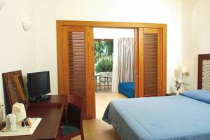 Hotelzimmer im Atlantica Beach Resort Kos mit Bett, Schreibtisch und Fernseher.