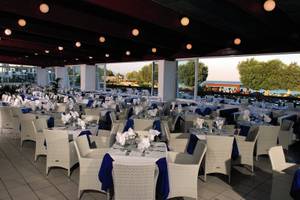 Restaurant im Atlantica Beach Resort Kos mit Blick auf das Meer und blau-weiß dekorierten Tischen.