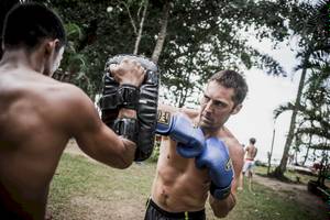 Zwei Männer boxen in einem Freiluft-Trainingslager.