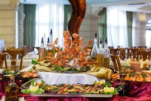 Buffet-Tisch im Lindos Princess Beach Hotel mit verschiedenen Meeresfrüchten und Olivenölflaschen.