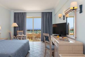 Hotelzimmer im Lindos Princess Beach Hotel mit Meerblick, Fernseher, Schreibtisch und Balkon.