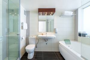 Badezimmer im Lordos Beach Hotel mit Dusche, Badewanne, Toilette und Waschbecken.