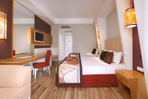 Innenansicht eines Hotelzimmers im Side Orange Palace mit zwei Betten, Schreibtisch und Möbeln.