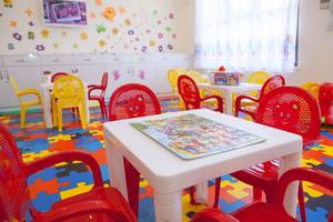 Kinderzimmer im Side Orange Palace Hotel mit bunten Stühlen und Puzzle auf dem Tisch.