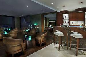 Barbereich des Sofitel Dubai The Palm Hotels mit gepolsterten Stühlen und einer Theke.