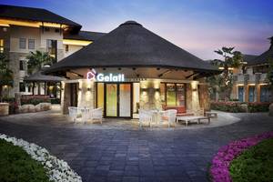 Außenansicht des Gelati Eiscafés im Sofitel Dubai The Palm mit Dach und Tischen draußen
