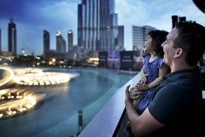 Vater und Tochter betrachten die Skyline von Dubai vom Balkon des Sofitel Dubai The Palm aus.