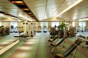Fitnesscenter im Sofitel Dubai The Palm mit verschiedenen Trainingsgeräten und Spiegeln.