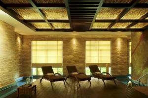 Innenbereich der Lounge im Sofitel Dubai The Palm mit drei Liegestühlen und einem Tisch