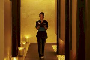 Mitarbeiterin des Sofitel Dubai The Palm Hotels mit Tablett in einem leuchtenden Gang