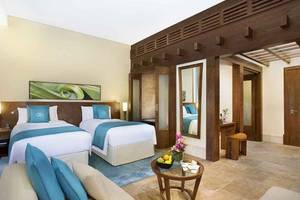Doppelbett-Zimmer im Sofitel Dubai The Palm mit zwei Betten, einem Tisch und einem Wohnzimmerbereich.