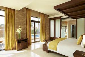 Schlafzimmer im Sofitel Dubai The Palm mit Poolblick und luxuriöser Einrichtung.