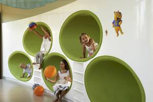 Kinder spielen in einem grünen, runden Spielzimmer im Sofitel Dubai The Palm.