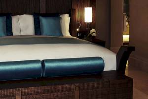 Sofitel Dubai The Palm Schlafzimmer mit blauen Kissen und Lampe