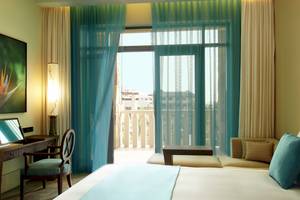 Suite Zimmer im Sofitel Dubai The Palm mit großem Bett, Balkon und Blick auf die Stadt