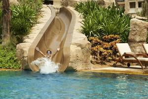 Ein Kind rutscht von einer Wasserrutsche in den Pool im Sofitel Dubai The Palm.