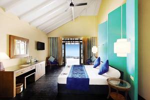 Hotelzimmer im Adaaran Select Meedhupparu mit Bett, Schreibtisch und Aussicht.