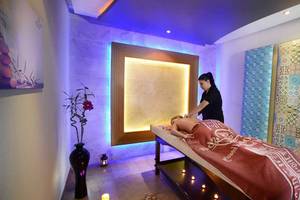 Eine Frau im schwarzen T-Shirt führt eine Massage in einem Hotelbehandlungsraum durch.