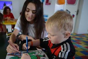 Eine Frau und ein kleiner Junge malen ein Bild im Pickalbatros White Beach Resort Kinderzimmer.